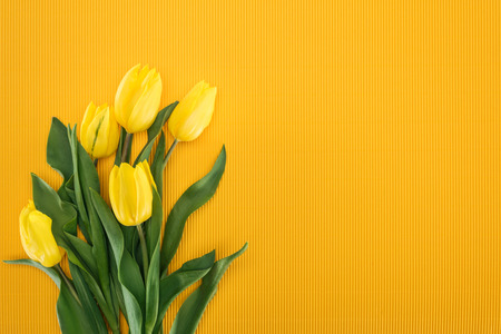 top view of bouquet with yellow tulips on orange background