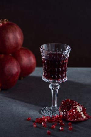 Studio shot of tasty garnets and vintage wineglassの写真素材