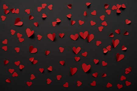 seamless black background with copy space and paper cut red heartsの写真素材