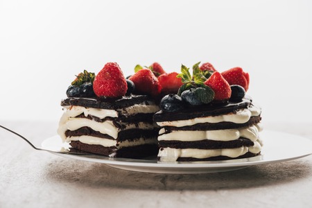 Pieces of gourmet whoopie pie cake with fresh berries on white plateの写真素材