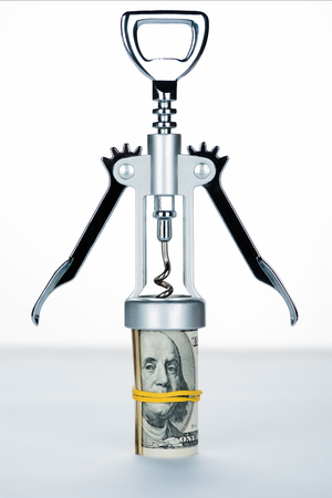 corkscrew with money roll on blurred white and grey backgroundの写真素材