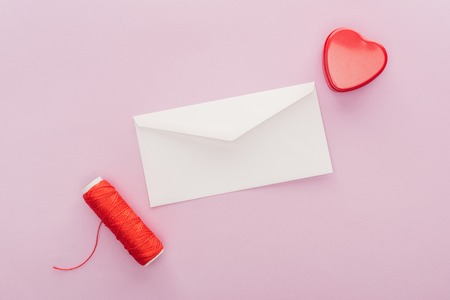 Top view of envelope and heart shaped gift box isolated on pink, st valentines day conceptの写真素材
