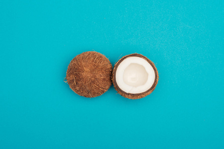 top view of ripe coconut halves on blue backgroundの写真素材