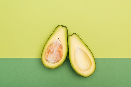 Top view of fresh ripe avocado halves on bicolor backgroundの写真素材
