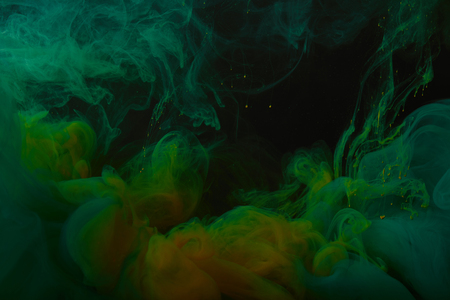 close up view of abstract background with green and orange swirls of paintの写真素材