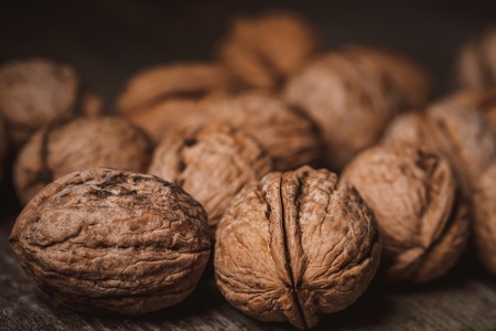 Close up view of walnuts on wooden tabletop on black backdropの写真素材