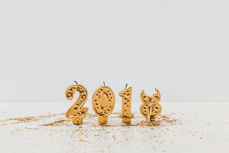 2018 candles and golden confetti on white backgroundの写真素材