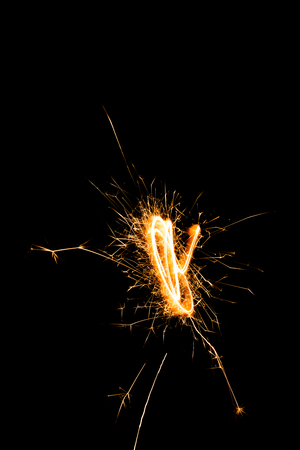 close-up view of festive burning christmas sparkler on black backgroundの写真素材