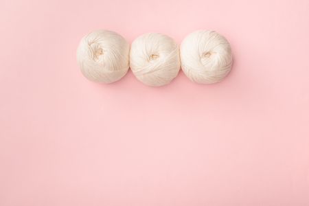 top view of white knitting clews on pink tabletopの写真素材