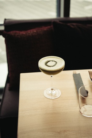 selective focus of delicious alcoholic cocktail with foam on wooden table in barの写真素材