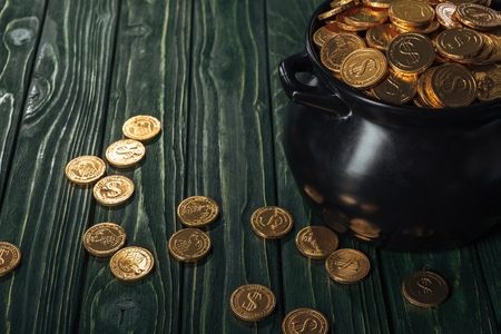 Golden coins in black pot on wooden background, st patrick day conceptの写真素材