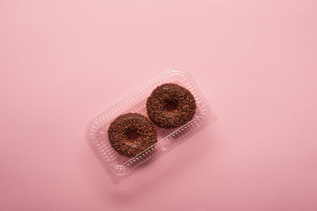 top view of chocolate donuts on pink backgroundの写真素材