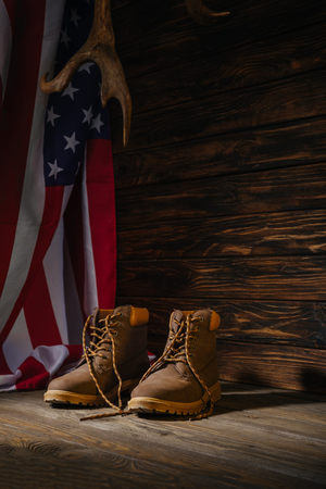 trekking boots, horns and american flag on wooden surface, travel conceptの写真素材