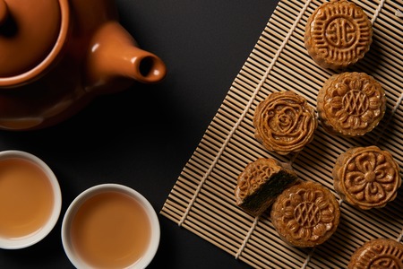 top view of traditional mooncakes, tea pot and cups on bamboo table matの写真素材
