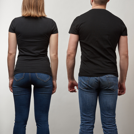 back view of young man and woman in black t-shirts with copy space isolated on grey
