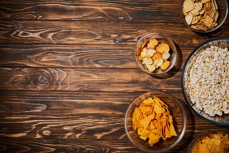 top view of snacks in bows on wooden table