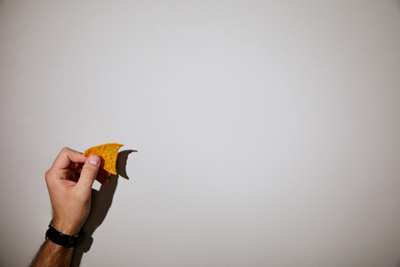 cropped view of man holding snack in hand on white backgroundの写真素材