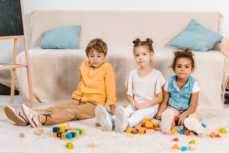 cute multiethnic kids playing with colorful cubes and looking at cameraの写真素材