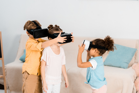 cute little children playing in virtual reality headsets togetherの写真素材