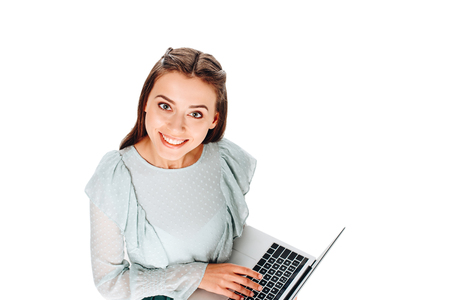 high angle view of young smiling woman with laptop isolated on whiteの写真素材