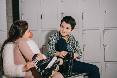 Kids in roller skates talking in locker roomの写真素材