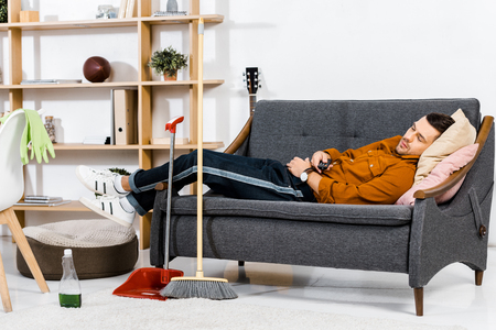 handsome man sleeping on sofa in modern living roomの写真素材