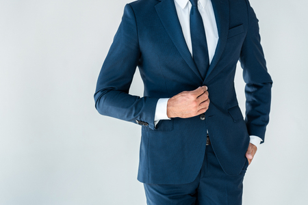 cropped image of businessman buttoning jacket isolated on whiteの写真素材