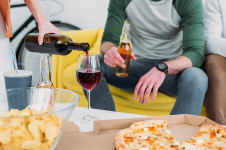 cropped view of man and woman near table with drinks and snacksの写真素材