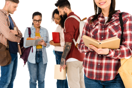 cropped view of girl with book near multicultural group of young students isolated on whiteの写真素材