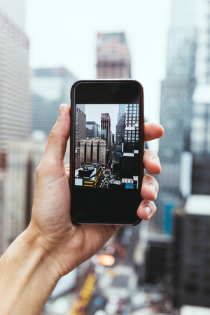 cropped shot fo man with smartphone taking picture of new york cityの写真素材