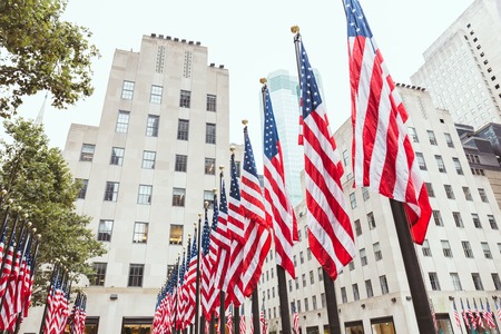 low angle view of american flags and buildings, new york, usaの写真素材