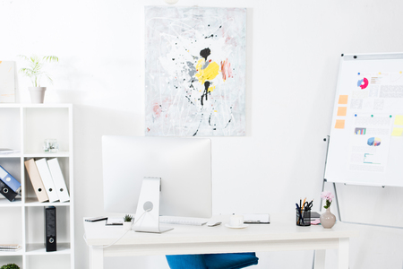 computer, paint and flipchart in business officeの写真素材