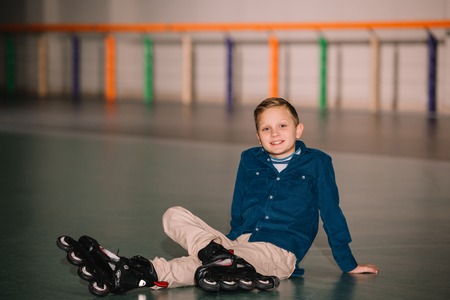 Roller boy in blue cardigan looking at camera with smile