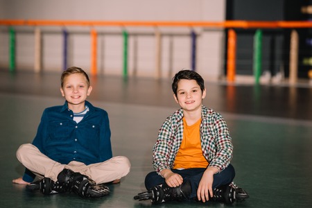 Little roller skaters looking at camera with smileの写真素材