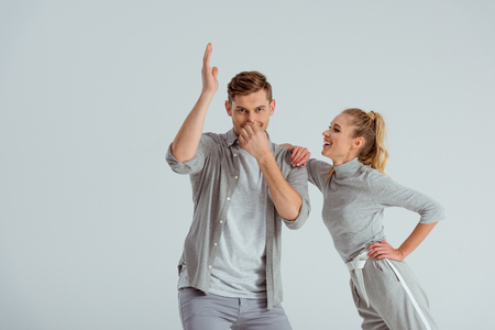 couple having fun and man doing swim dance move isolated on greyの写真素材