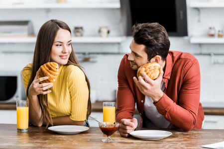 selective focus of happy couple having breakfast in kitchenの写真素材