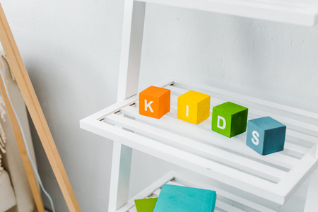 close up view of multicolored cubes with kids lettering on shelfの写真素材