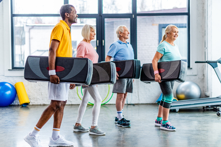 happy multiethnic sportspeople holding step platforms at gymの写真素材