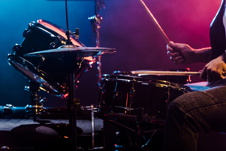 cropped shot of male musician performing on drums during rock concert on stageの写真素材