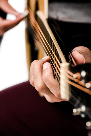 cropped image of male musician playing on acoustic guitar isolated on white