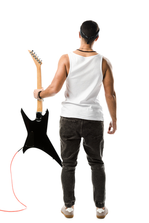back view of male rock musician posing with black electric guitar isolated on whiteの写真素材