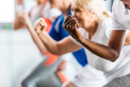 cropped shot of senior sportspeople synchronous exercising at sports hall