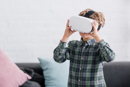 adorable little boy using virtual reality headset at homeの写真素材