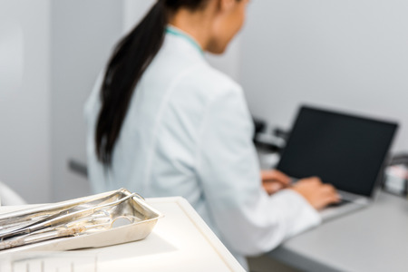 selective focus of instruments near female doctor typing on laptopの写真素材