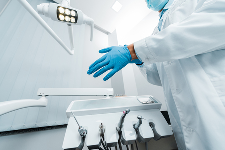 cropped view of male dentist wearing latex gloveの写真素材