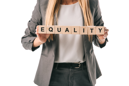 cropped view of businesswoman holding alphabet cubes with equality word, isolated on whiteの写真素材