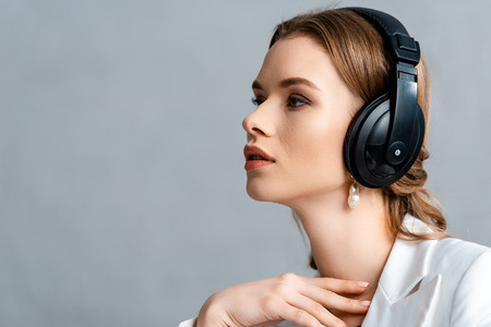portrait of beautiful woman listening music in headphones and looking away with copy spaceの写真素材
