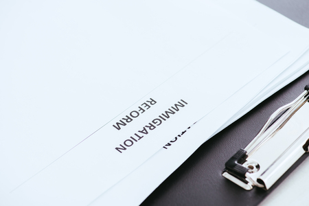 document with immigration reform lettering near clipboard