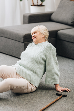 retired woman with blonde hair sitting on floor and having painの写真素材