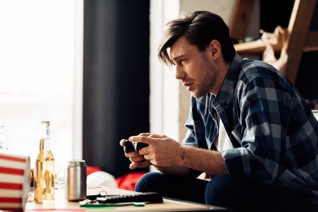 sleepy man  playing video game at homeの写真素材